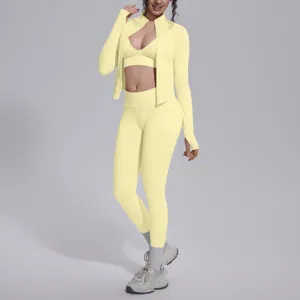 Completo sportivo senza cuciture in tre pezzi, giacca gialla con zip e leggings.