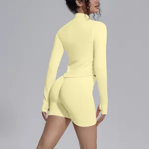 Back view detail of yellow seamless long sleeve athletic top and matching shorts fitness set.