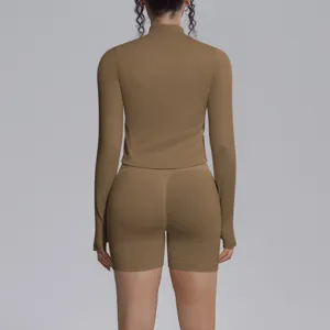 Seamless solid color high-elastic long sleeve crop top and shorts yoga set for fitness running.