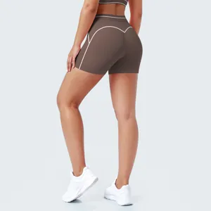 Gedetailleerd overzicht van bruine sportshorts met witte contraststiksels en aansluitende pasvorm.