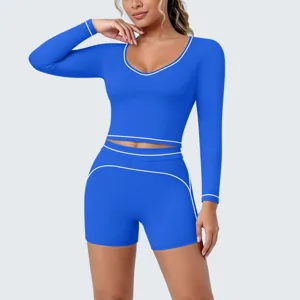 Close-up detail of the royal blue long sleeve crop top featuring stylish white contrast piping.