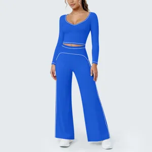 Details des blauen Langarm-Crop-Tops und der weiten Yogahose mit kontrastierenden Bändern.