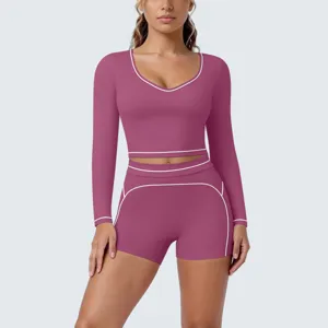 Detail view of women contrast piping long sleeve crop top and fitted shorts fitness activewear set.