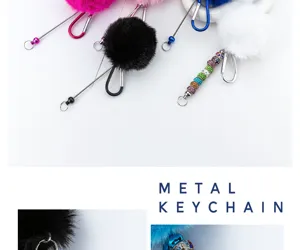 Detailaufnahme des flauschigen Pompon-Schlüsselanhängers mit Karabiner und bunten Perlen.