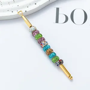 Stainless steel dual-ended cuticle pusher with colorful rhinestones for professional nail art care.