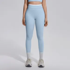 Vue détaillée de leggings de yoga taille haute bleu clair, ceinture contrastée et coupe extensible.