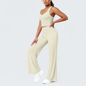 Vue détaillée d'un ensemble crop top de sport beige et pantalon de yoga évasé liseré blanc.