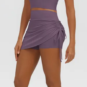 Detail of high-waist purple yoga skirt with side ruching and drawstring, breathable fabric.
