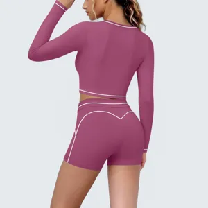 Detailed view of women's long sleeve crop top and shorts activewear set with contrast piping.