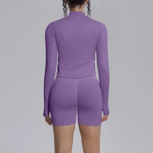 Seamless purple long sleeve athletic top and matching fitness shorts for women workout gym.