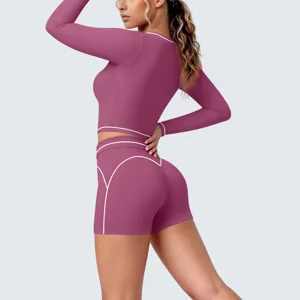 Close-up detail of women athletic long-sleeve crop top and shorts set with contrast piping.