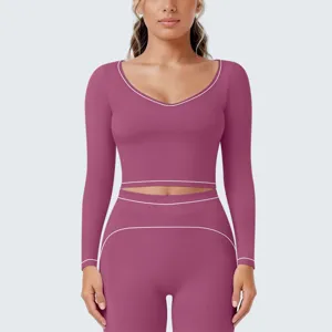 Gedetailleerd overzicht van sport crop top met lange mouwen en legging met contrasterende bies.