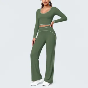 Grünes Langarm-Crop-Top und ausgestellte Yogahose mit weißen Paspeln für das Fitnesstraining.