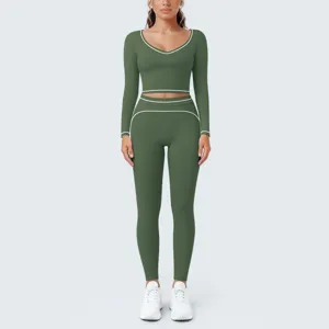 Detailed view of the dark green athletic crop top and leggings set with white contrast piping.