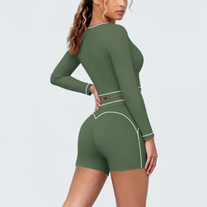 Dark green athletic long sleeve crop top and shorts set with white piping, detail view.