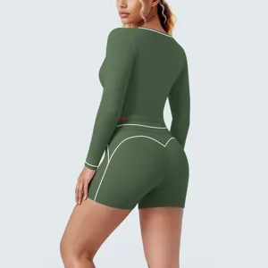 Detail view of the green long sleeve sports top and shorts set with white contrast piping.
