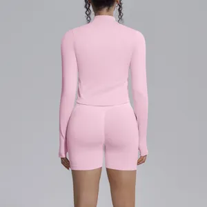 Detailed back view of women pink seamless long sleeve yoga top and fitness shorts set.