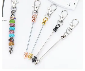 Detail view of creative DIY beaded metal keychain with lobster clasp and bullet rod charm.