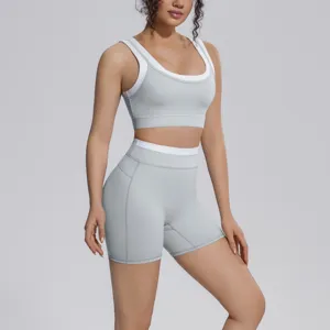 Women grey two-piece sports yoga set with padded bra and high waist fitness shorts.