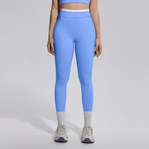 Gros plan detail du legging de sport taille haute avec ceinture contrastée en couleur bleue.