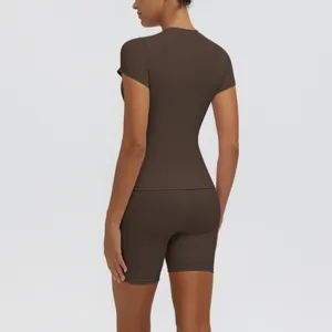 Vue arrière d'un haut de sport marron foncé à manches courtes et d'un short de fitness moulant.