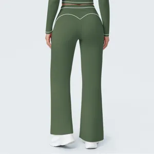 Close-up detail of high-waisted green yoga flare pants with stylish white contrast piping.
