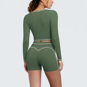 Back view detail of army green long sleeve crop top and shorts yoga set with white contrast piping.