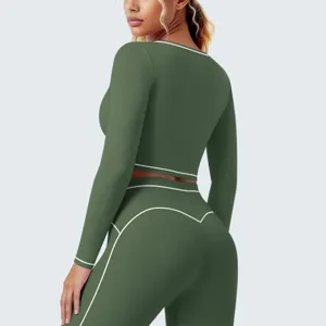Gedetailleerd shot van de olijfgroene sportieve crop-top met lange mouwen en witte bies.