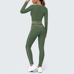 Detailed view of the green long-sleeve crop top and high-waist yoga pants set with white piping.