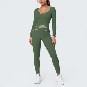 Detailed view of the dark green long-sleeve crop top and leggings fitness set with white piping.
