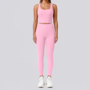 Pink fitness crop top and leggings detail view, breathable athletic wear for gym workout.