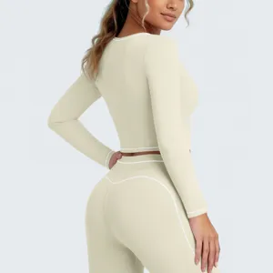 Dames sport lange mouw crop top en hoge taille leggings fitness set in neutrale nude tint.