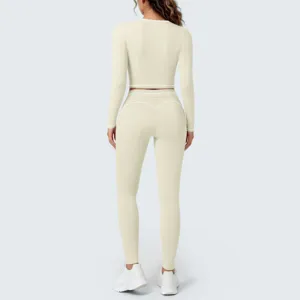 Back view of a beige long sleeve crop top and leggings yoga set with white trim details.