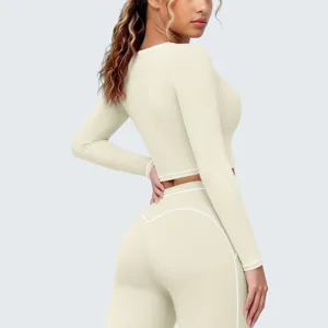 Nahaufnahme des atmungsaktiven langärmligen Fitness-Crop-Tops und Leggings-Sets in Creme.