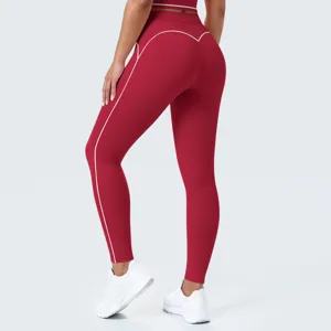Vista detallada de leggings de yoga rojos de talle alto con costuras blancas y zapatillas.