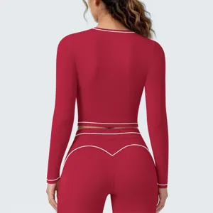 Gedetailleerd achteraanzicht van rode sporttop met lange mouwen en bijpassende fitnessbroek.