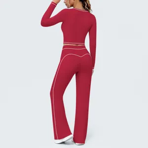 Detailansicht des roten Sportsets mit weißen Kontrastpaspeln und Schlaghosen für Yoga und Fitness.