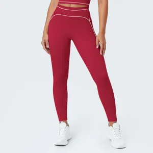 Vista detallada de leggings de yoga rojos de talle alto para mujer con ribetes en contraste.