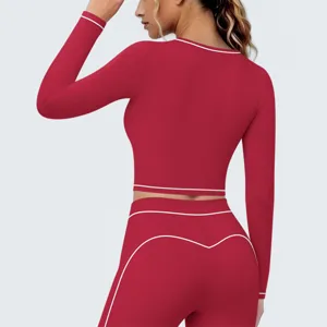 Gedetailleerd overzicht van rode sport crop top en leggings set met stijlvolle witte bies.