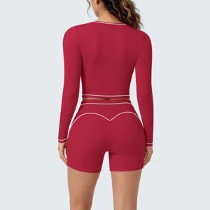 Back view detail of the red long sleeve crop top and shorts set with white piping.