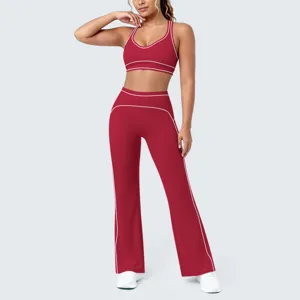 Dettaglio set yoga rosso con reggiseno sportivo e pantaloni a zampa con profili bianchi.