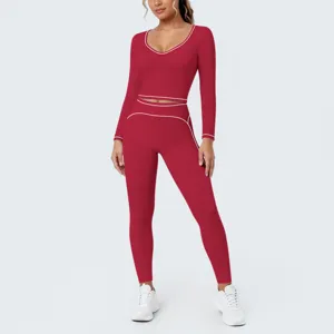 Red long sleeve crop top yoga set detail view showing white contrast piping and leggings.