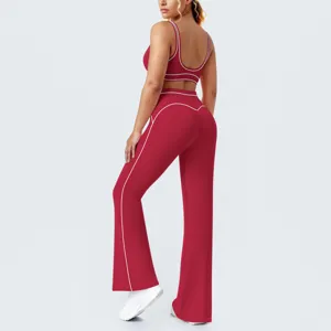 Completo yoga rosso bicolore con reggiseno sportivo schiena scoperta e pantaloni a zampa fitness.