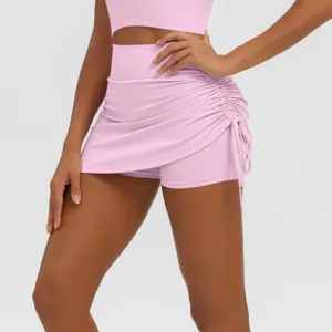 Close-up detail of the pink high-waisted ruched athletic skirt with built-in shorts for women.