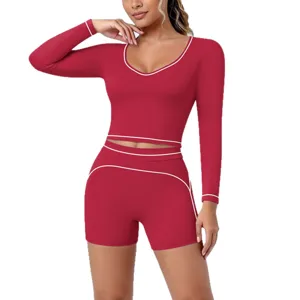 Red long sleeve crop top and shorts yoga set with white contrast piping for active fitness.