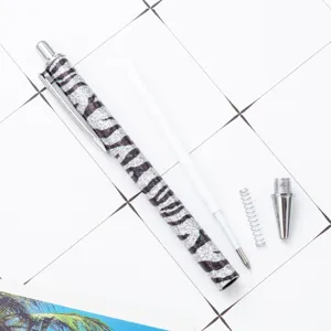 Glitter zebra pattern metal ballpoint pen with refill spring and tip flatlay view