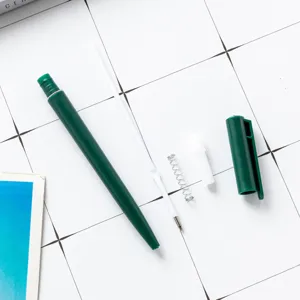 Green plastic ballpoint pen disassembled display with refill spring and cap for office business