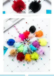 Detail view of colorful fluffy pom-pom beaded ballpoint pens, creative student stationery.