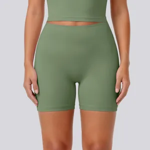 Close-up detail of high-waisted green yoga shorts and matching activewear top, breathable.