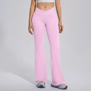 Detail view showing the crossover high waist and flared leg design of the pink yoga pants.